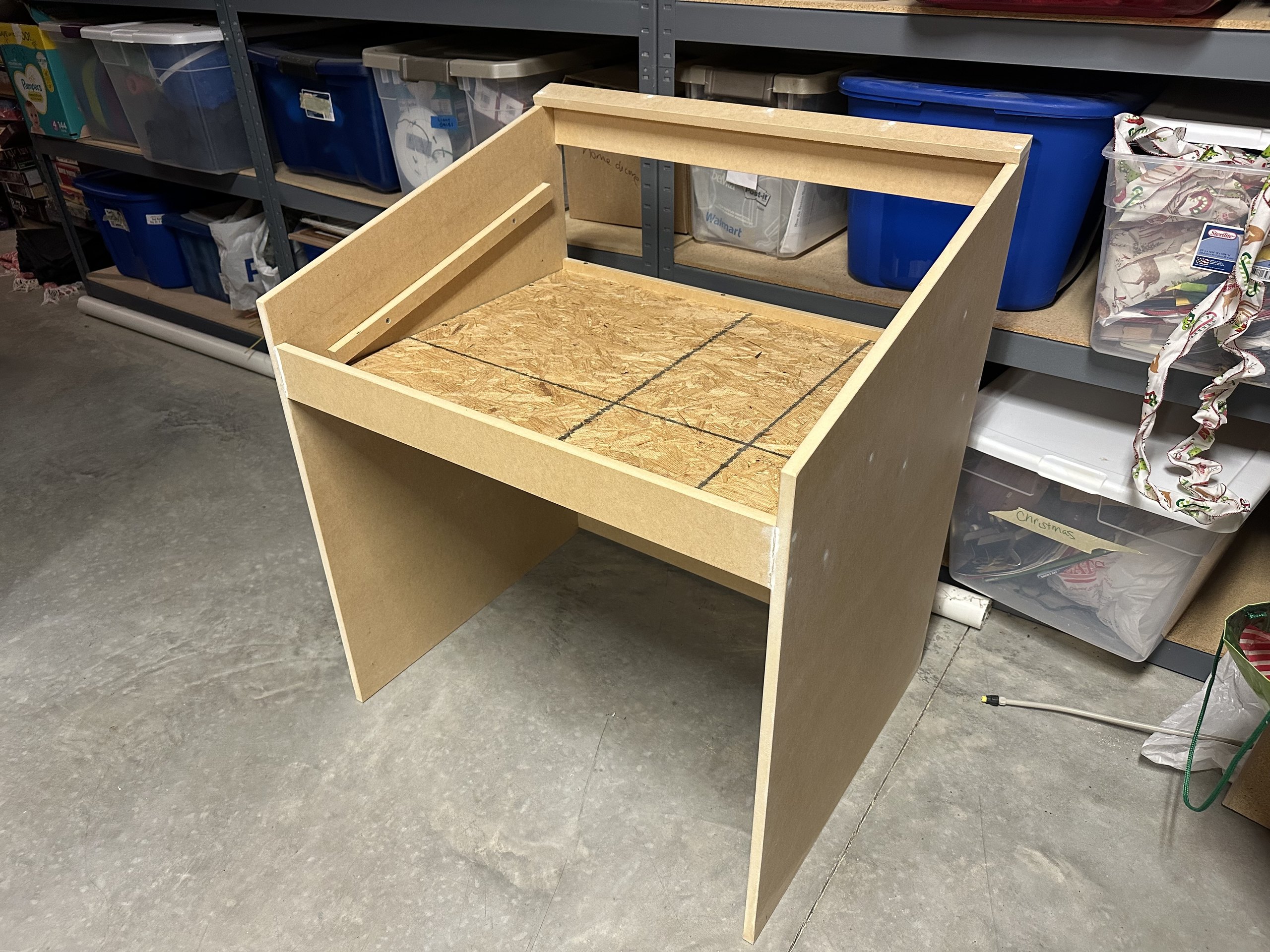 Assembled unpainted MDF desk frame with a plywood wiring tray
