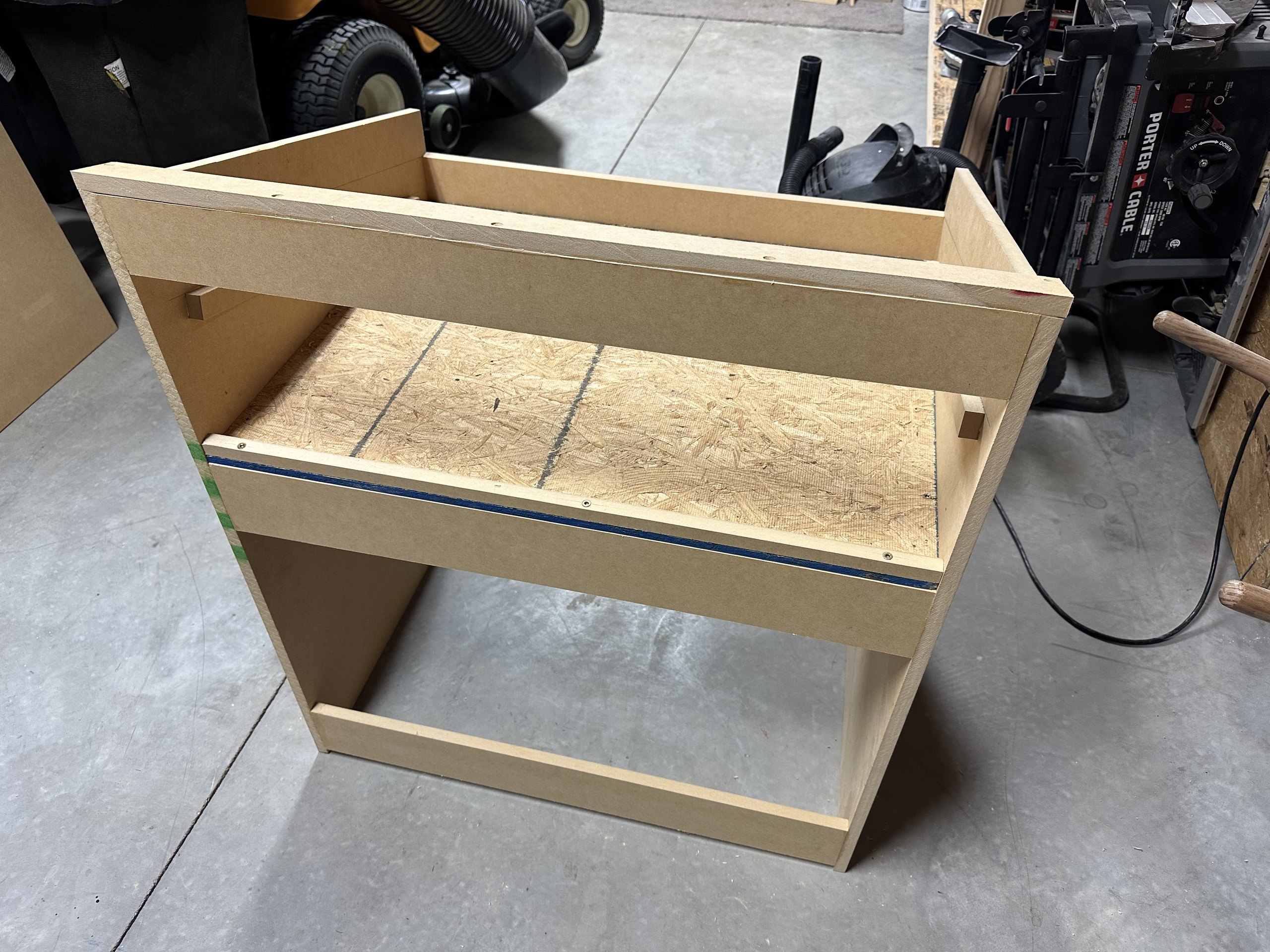 Unpainted desk viewed from above, showing the plywood wiring tray and its back lip