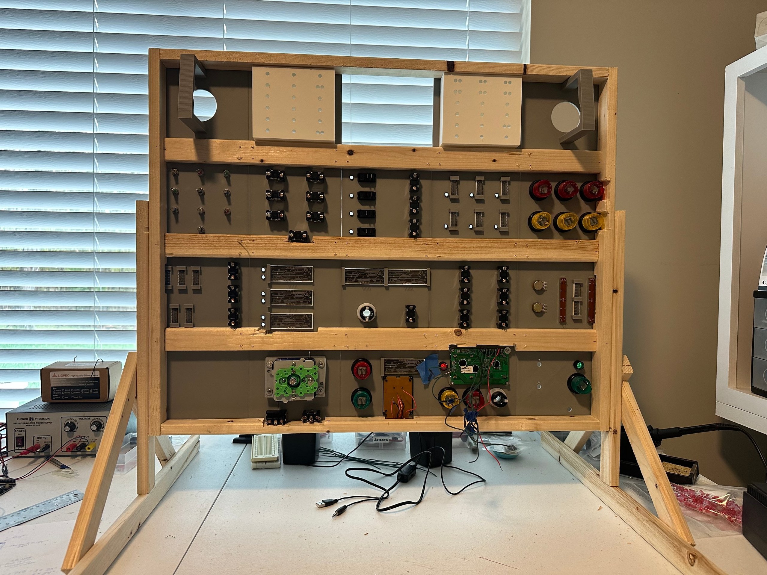 Back of the panel frame on a wooden wiring stand, showing the switches and components ready for wiring