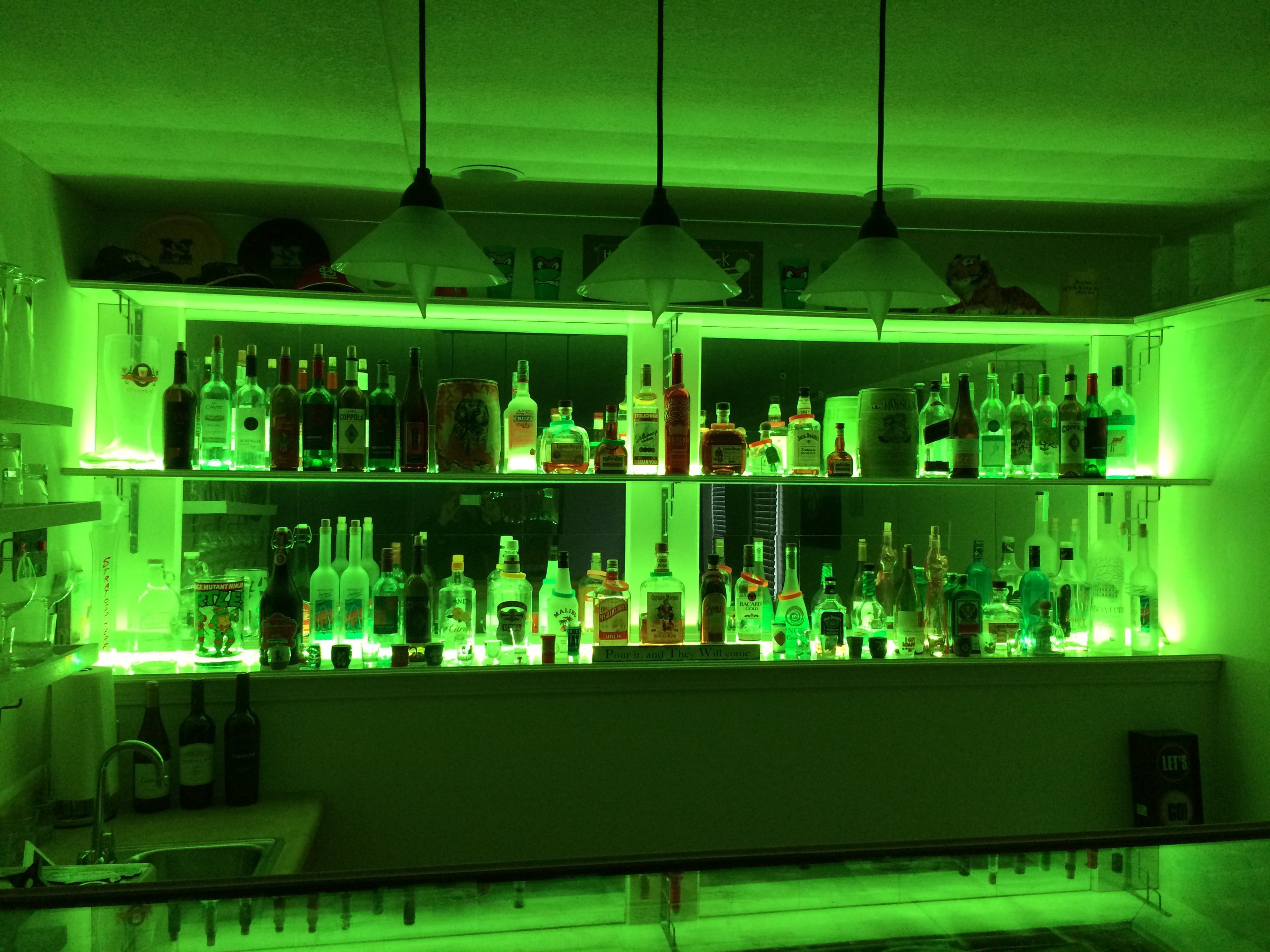 Basement bar shelves glowing green from the LED Bar lights