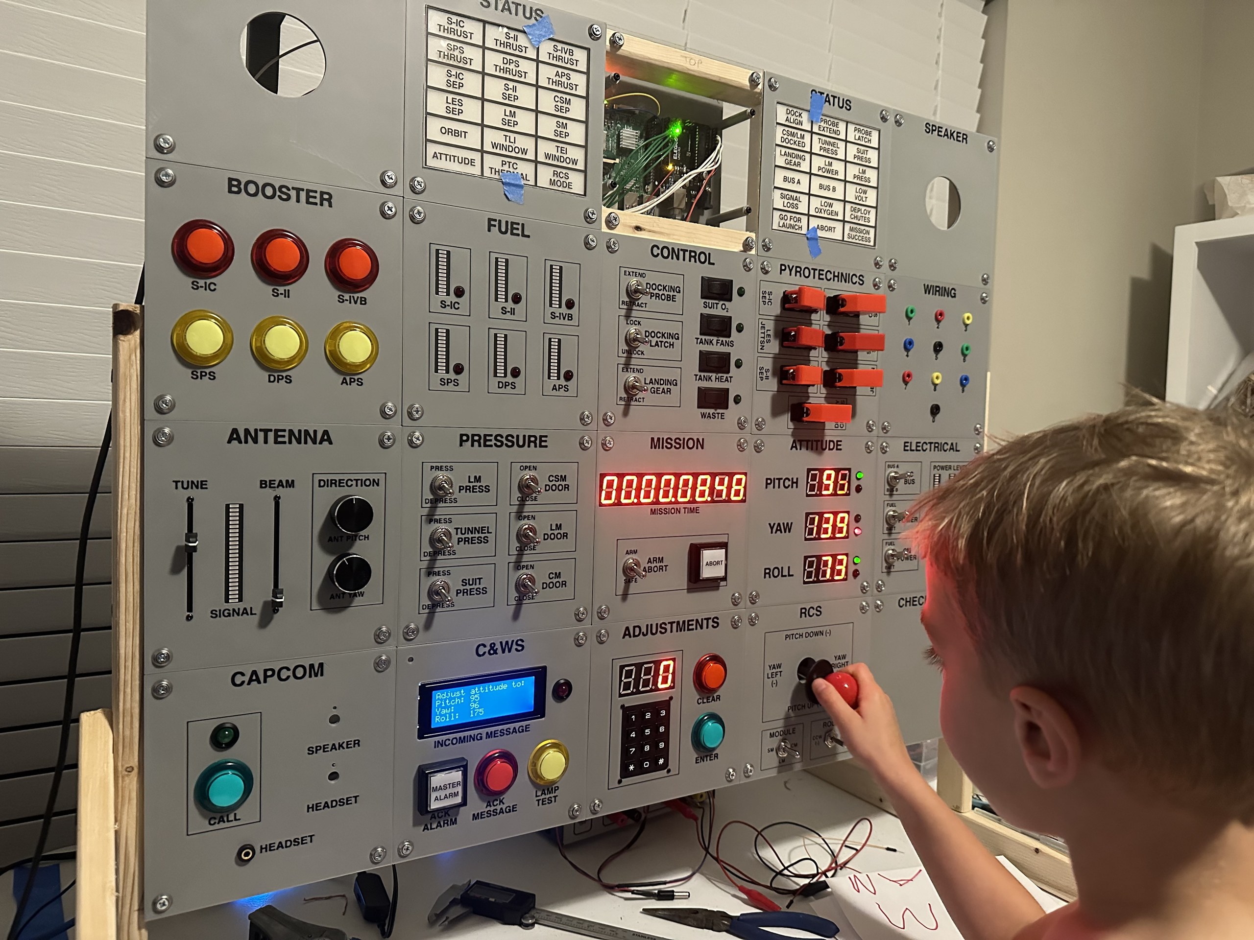 Child testing the lit-up Apollo simulator panel with the RCS joystick
